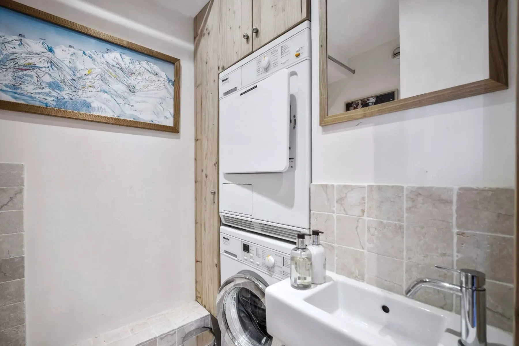 A laundry area with a stacked washer and dryer beside a sink.