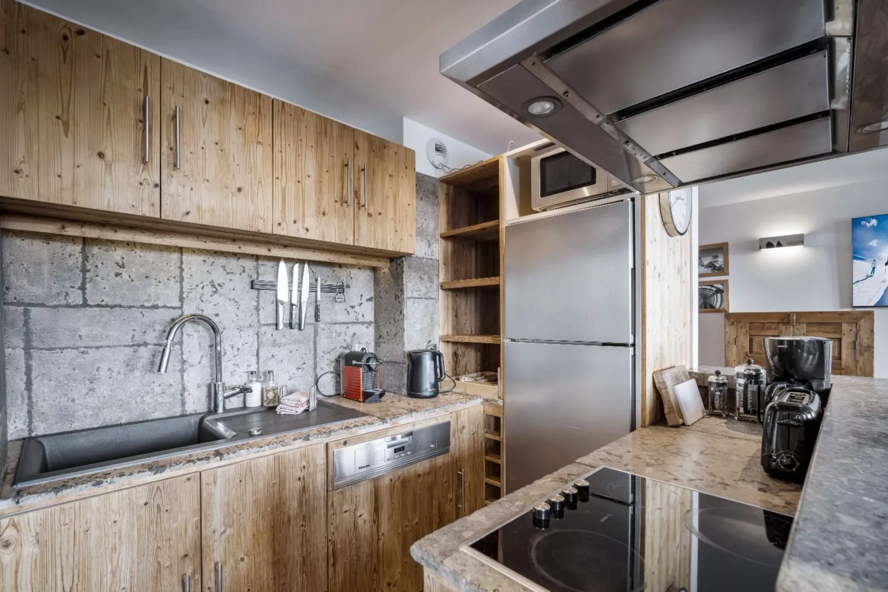 A kitchen with wood cabinets, a sink, and a refrigerator.