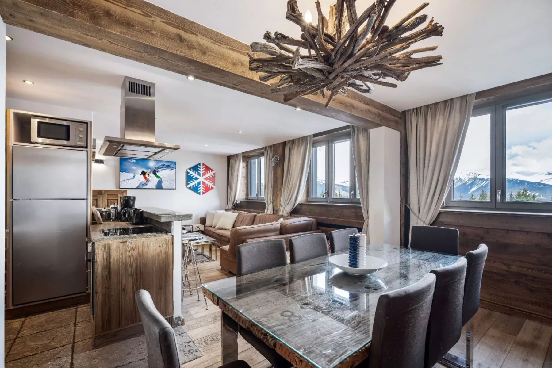 An open-plan living and dining area with a kitchen and large windows.