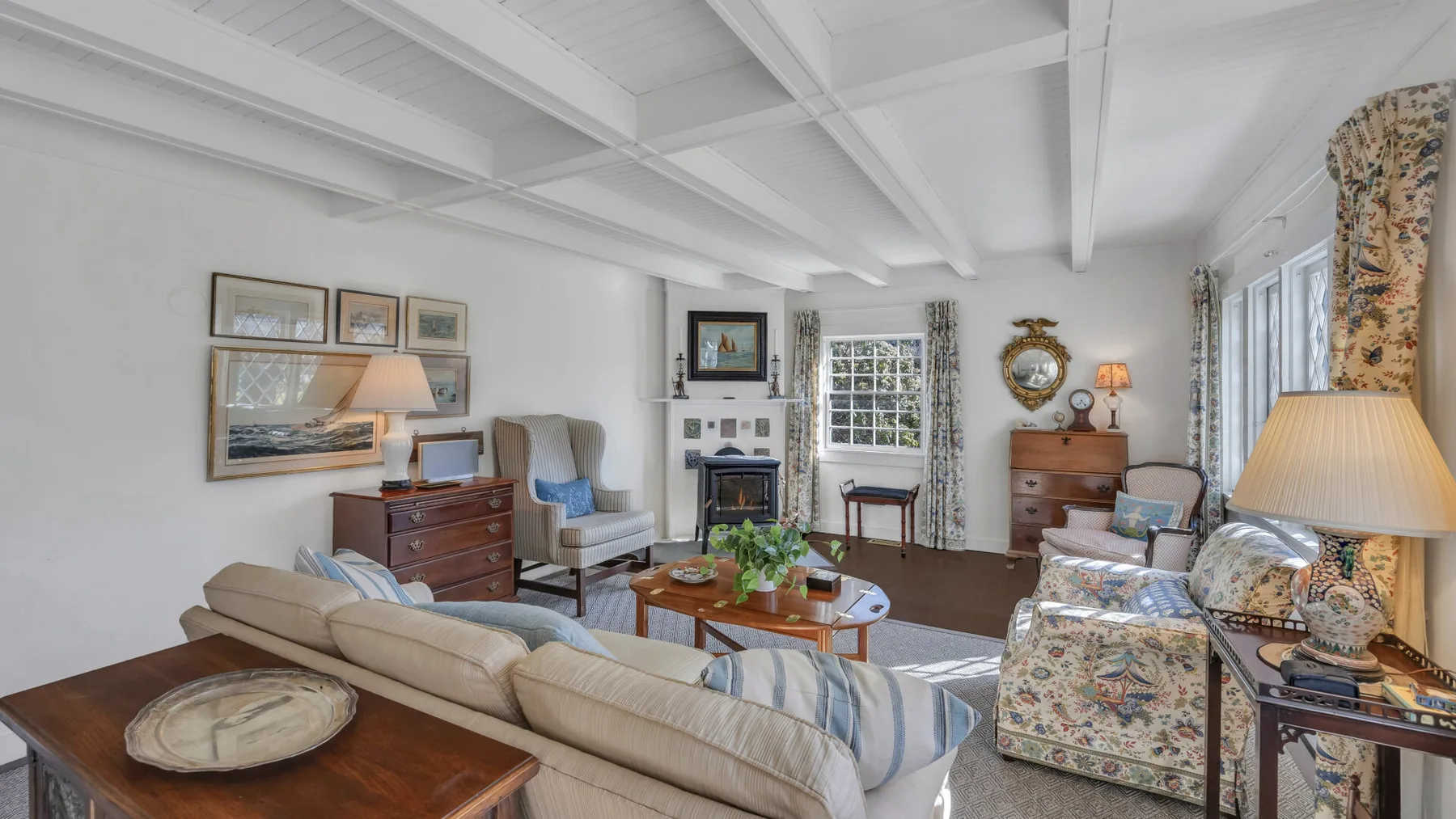 A bright living room with seating arranged around a coffee table and fireplace.