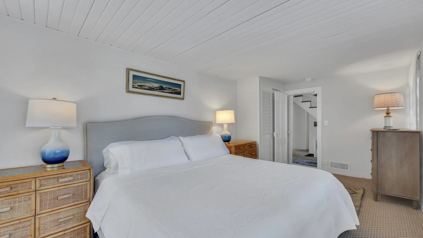 Bedroom with a bed, bedside tables, and a doorway to an adjoining room.