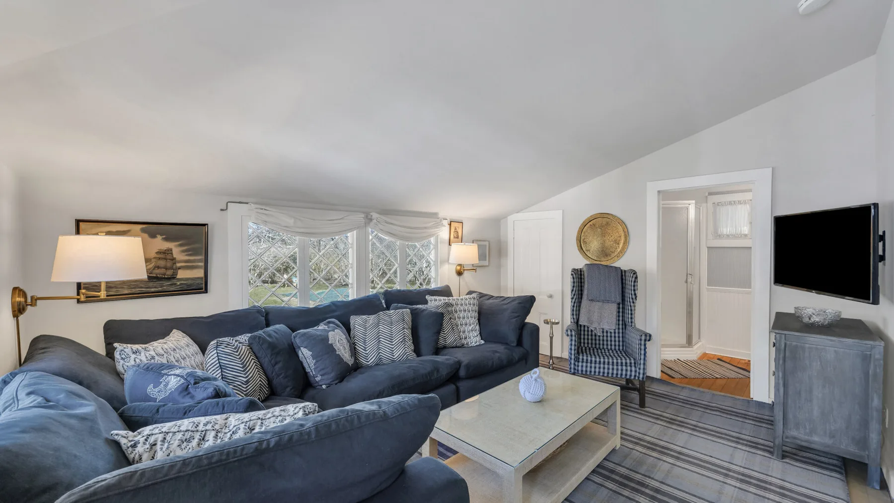A living room with a sectional seating area, coffee table, and wall-mounted television.
