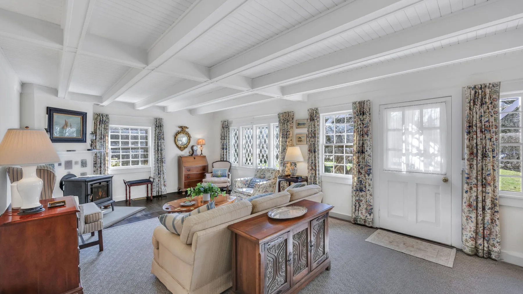 A bright living room with seating arranged around a coffee table.