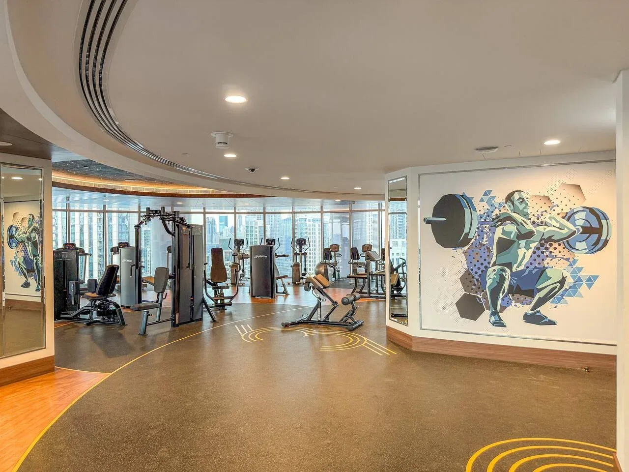 A gym with exercise equipment and a large athlete mural.