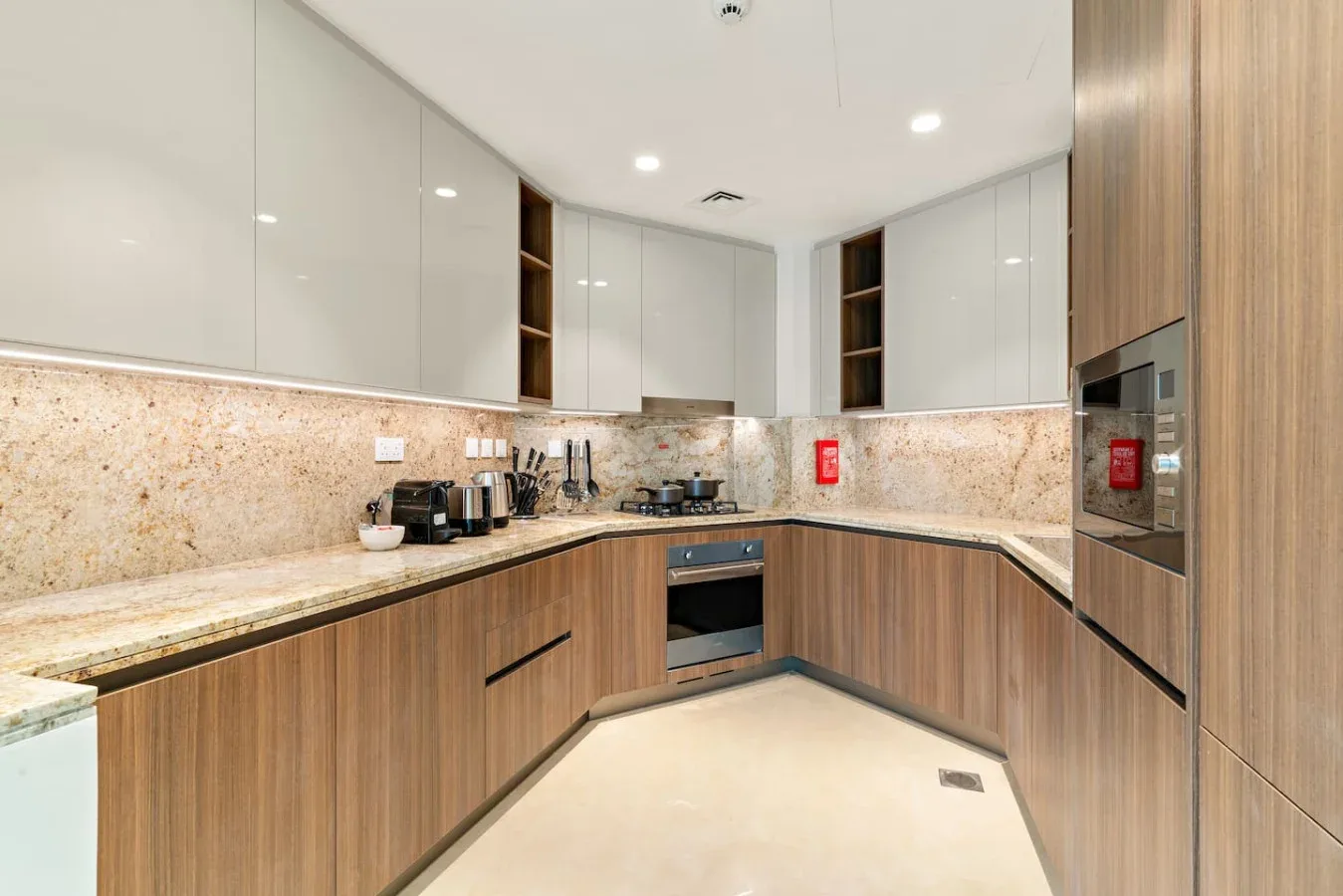 A modern kitchen with wood-toned cabinets and light countertops.