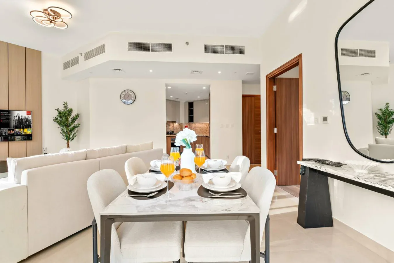A bright dining area with a set table beside a living room.