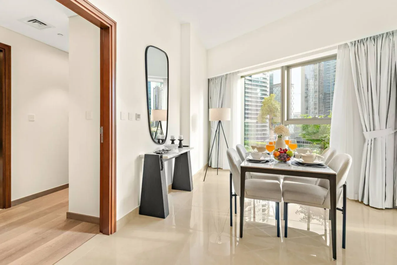 A bright dining area with a set table beside large windows.