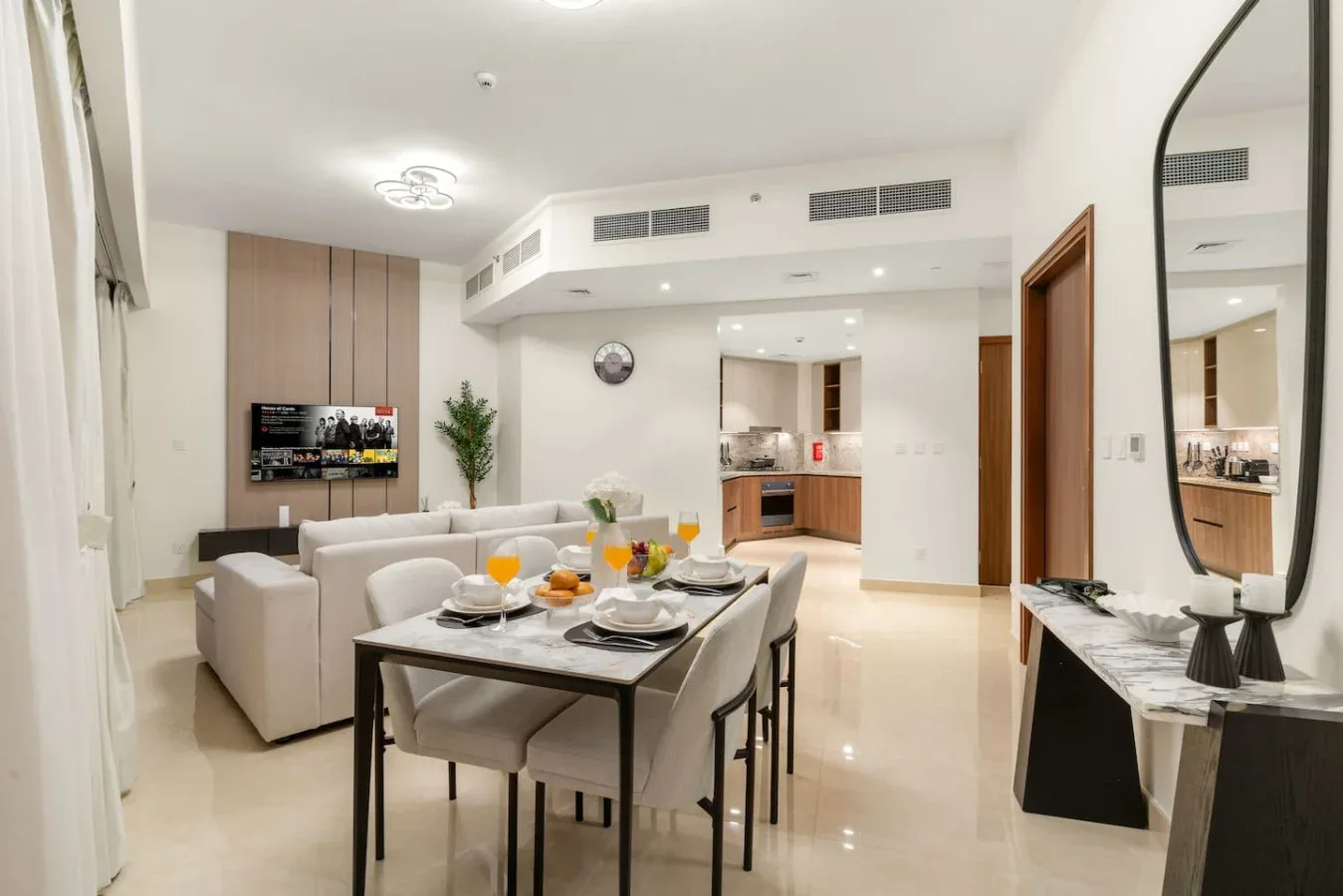 A bright dining and living area with a set table and seating.