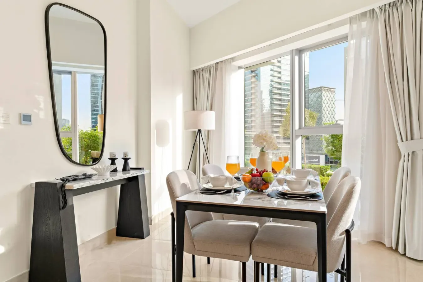 A bright dining area with a set table beside large windows.