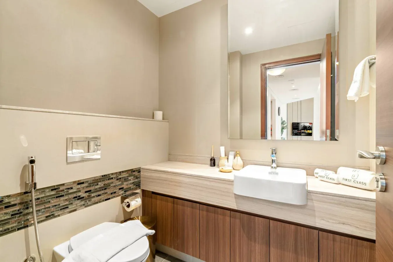 A modern bathroom with a wide vanity, wall mirror, and tiled shower area.