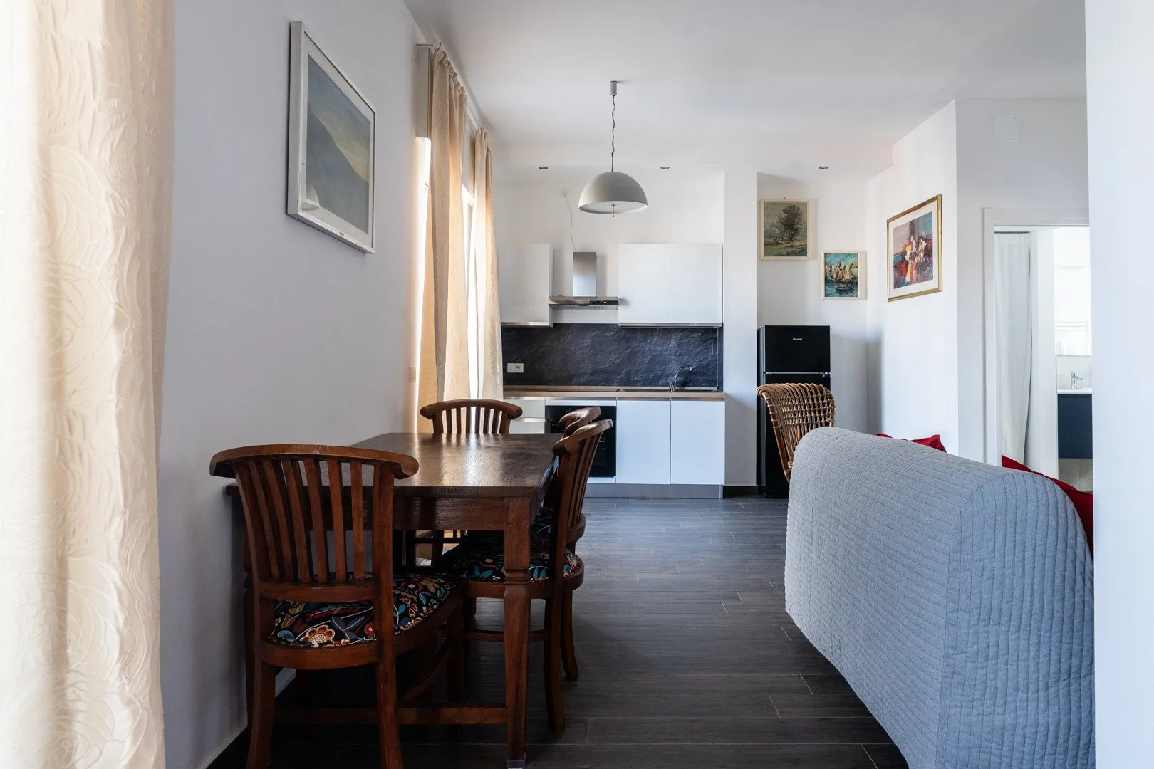 Una zona abierta de comedor y cocina con una mesa de madera.