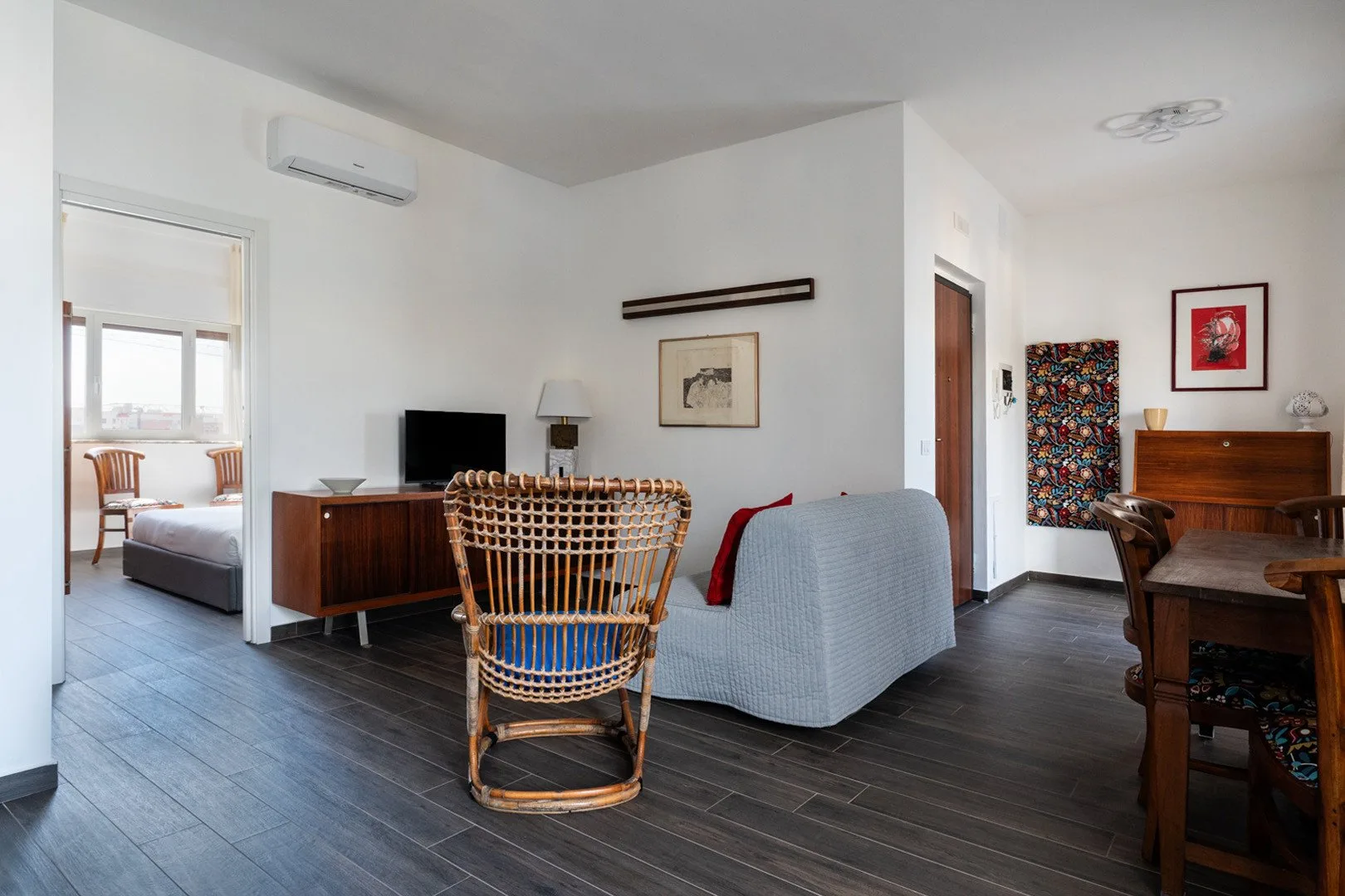 Una sala luminosa con asientos, un televisor y un comedor contiguo.