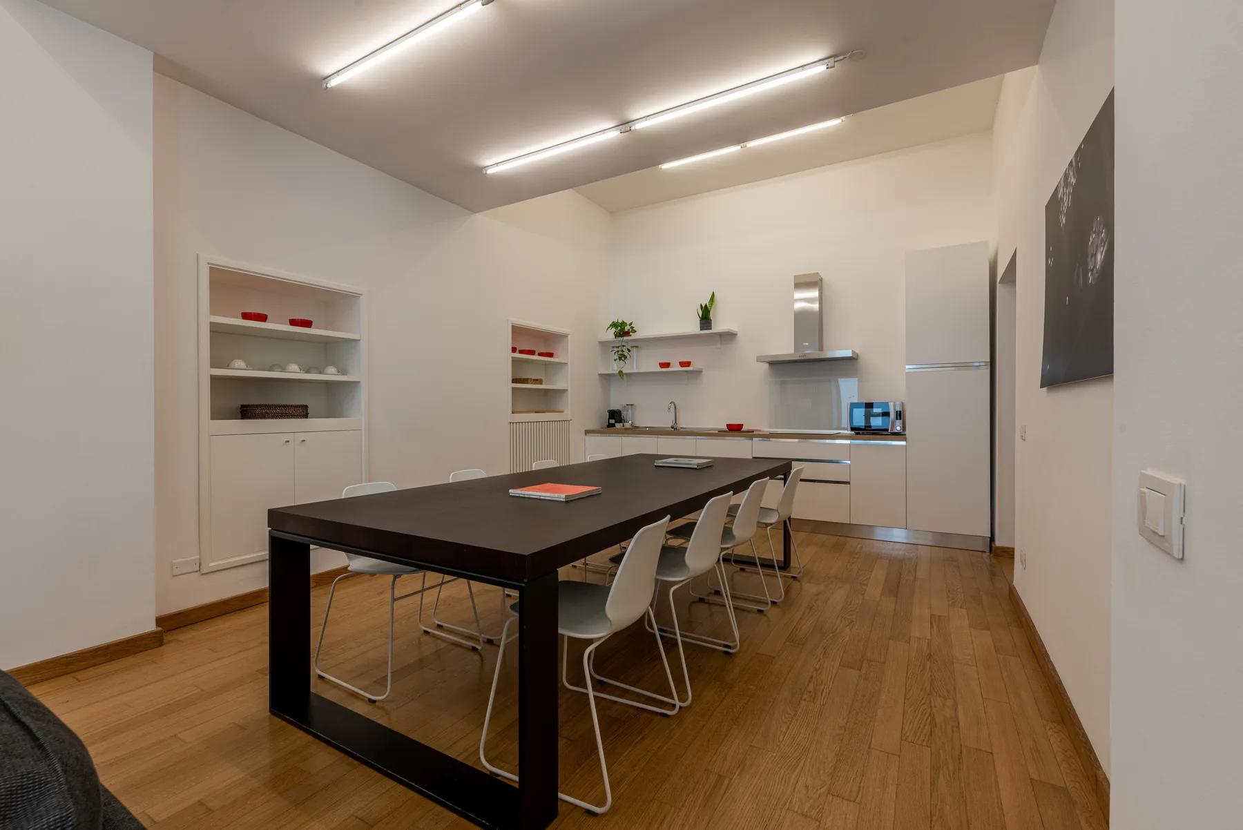 Una cocina y comedor luminosos con una mesa larga y asientos alrededor.