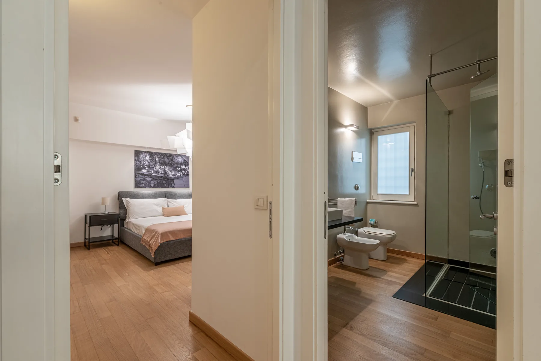 Se ven un dormitorio y un baño contiguo a través de una puerta abierta.