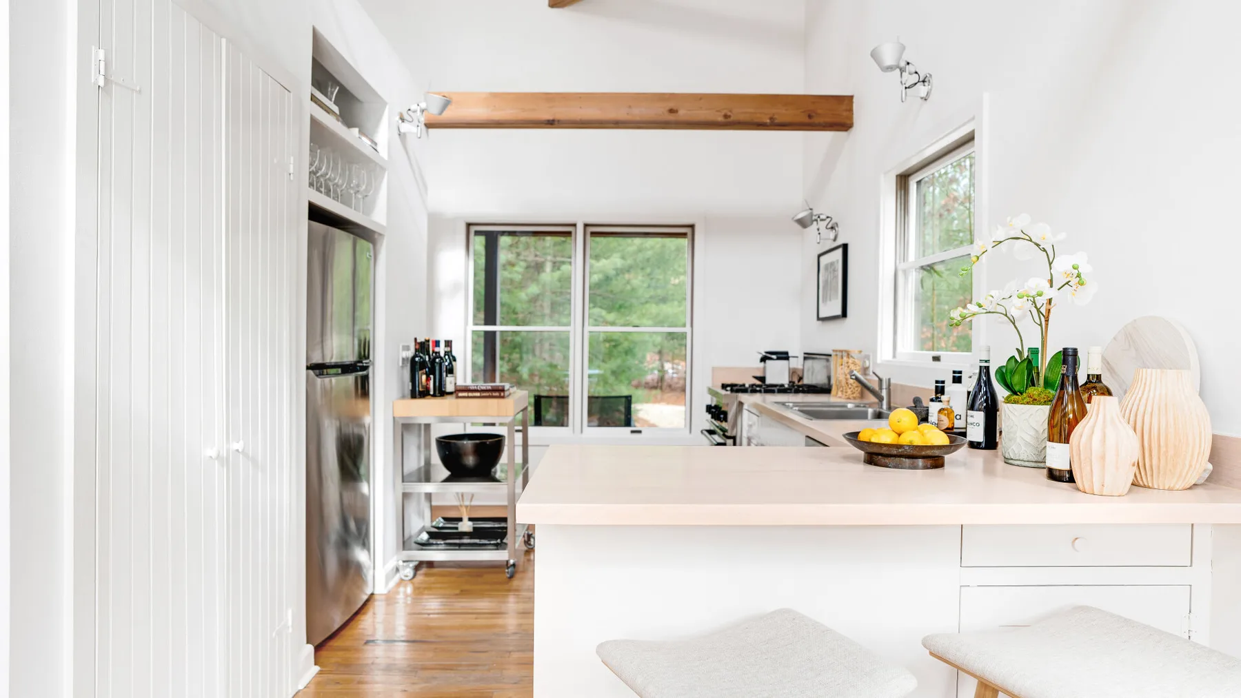 A bright kitchen with a central island and large windows.