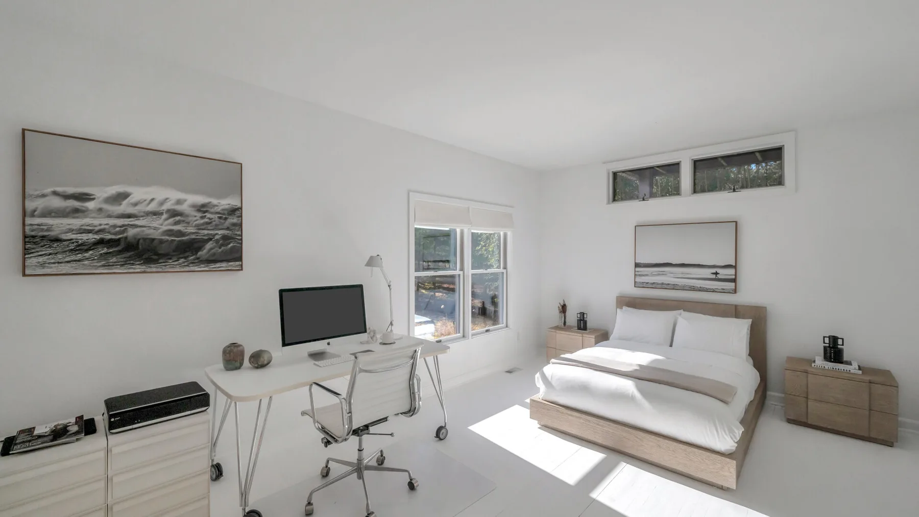 A bright bedroom with a bed, desk, and large windows.