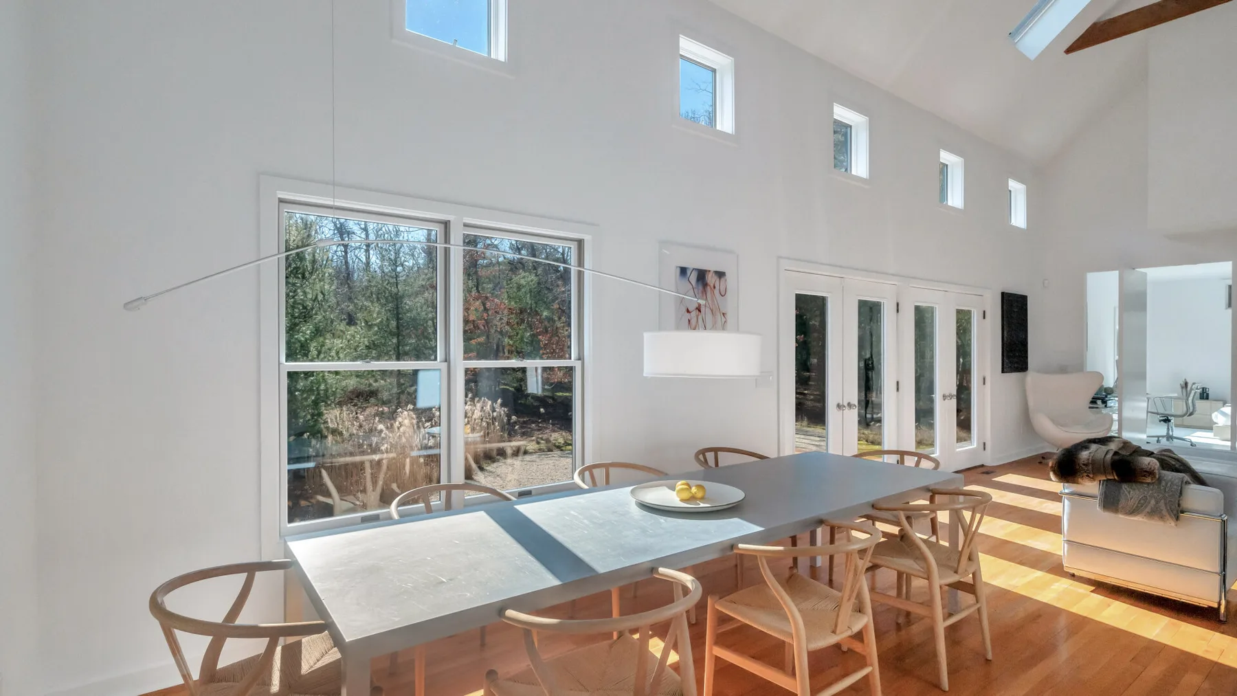 A bright dining area with a long table and large windows.
