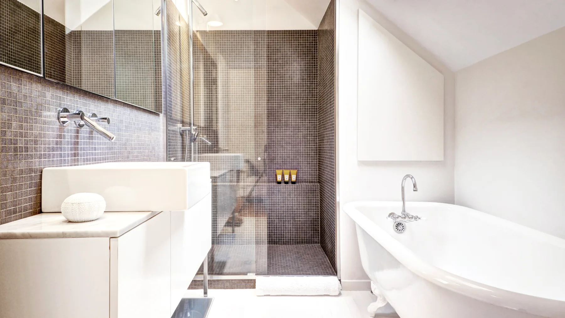 A bright bathroom features a white bathtub beside a glass shower.