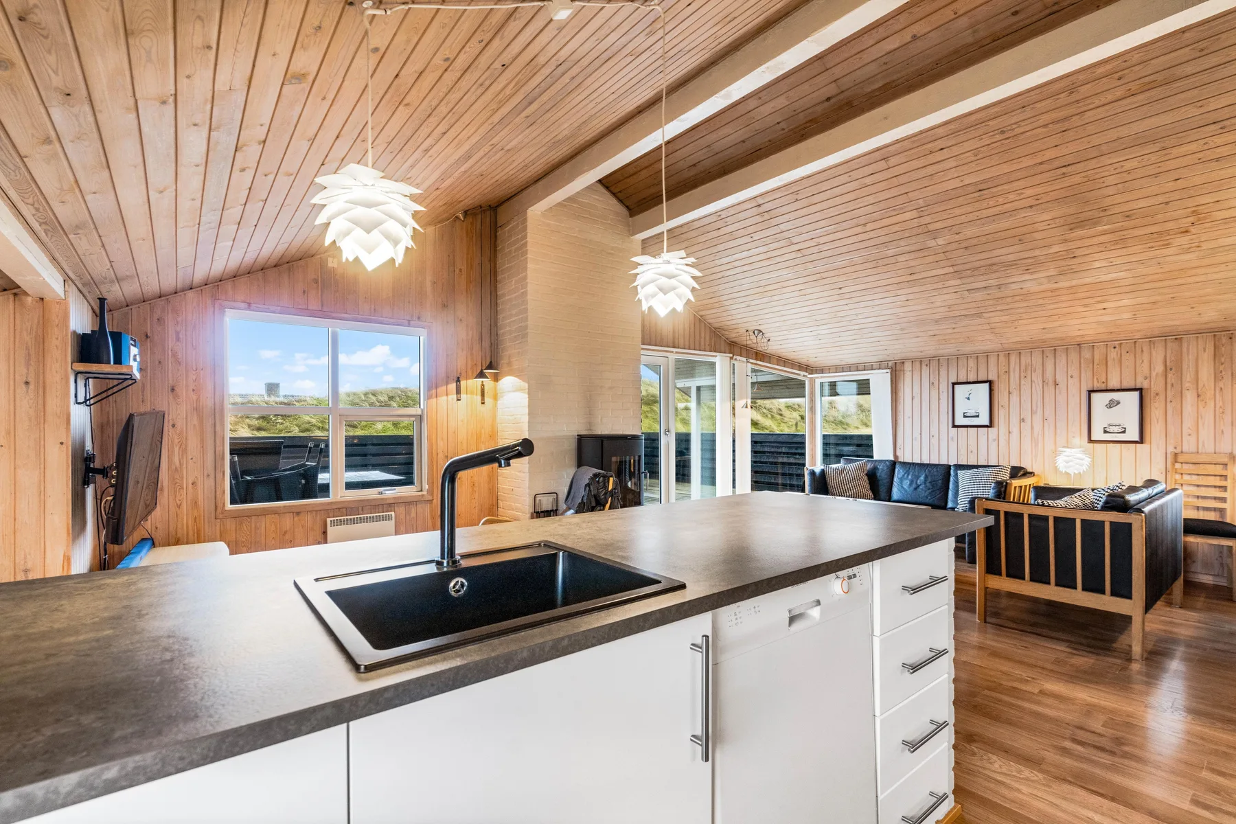 Una cocina luminosa integrada con la sala cuenta con una isla grande y una mesa de comedor.