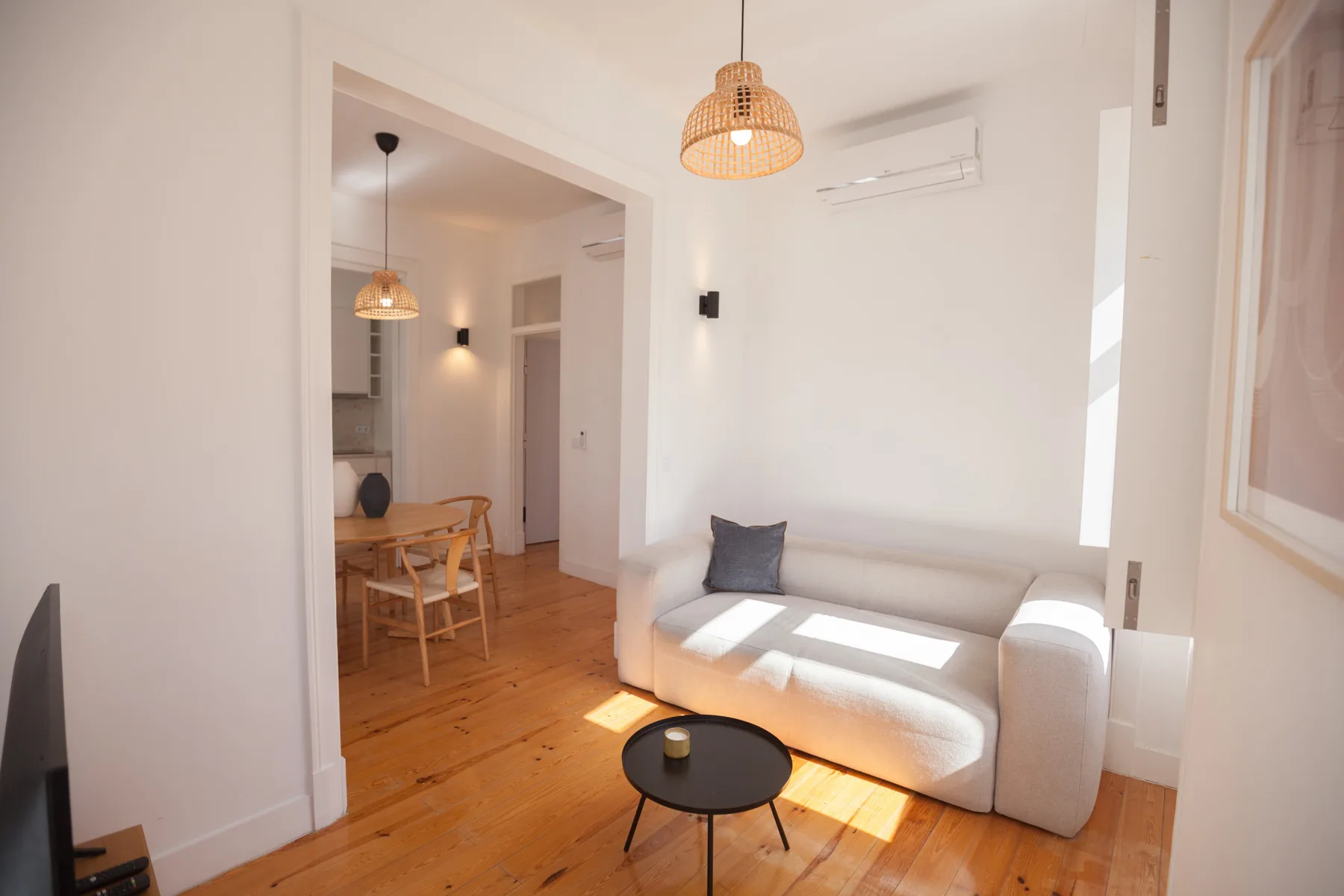 A bright living room with a sofa and a small round coffee table.