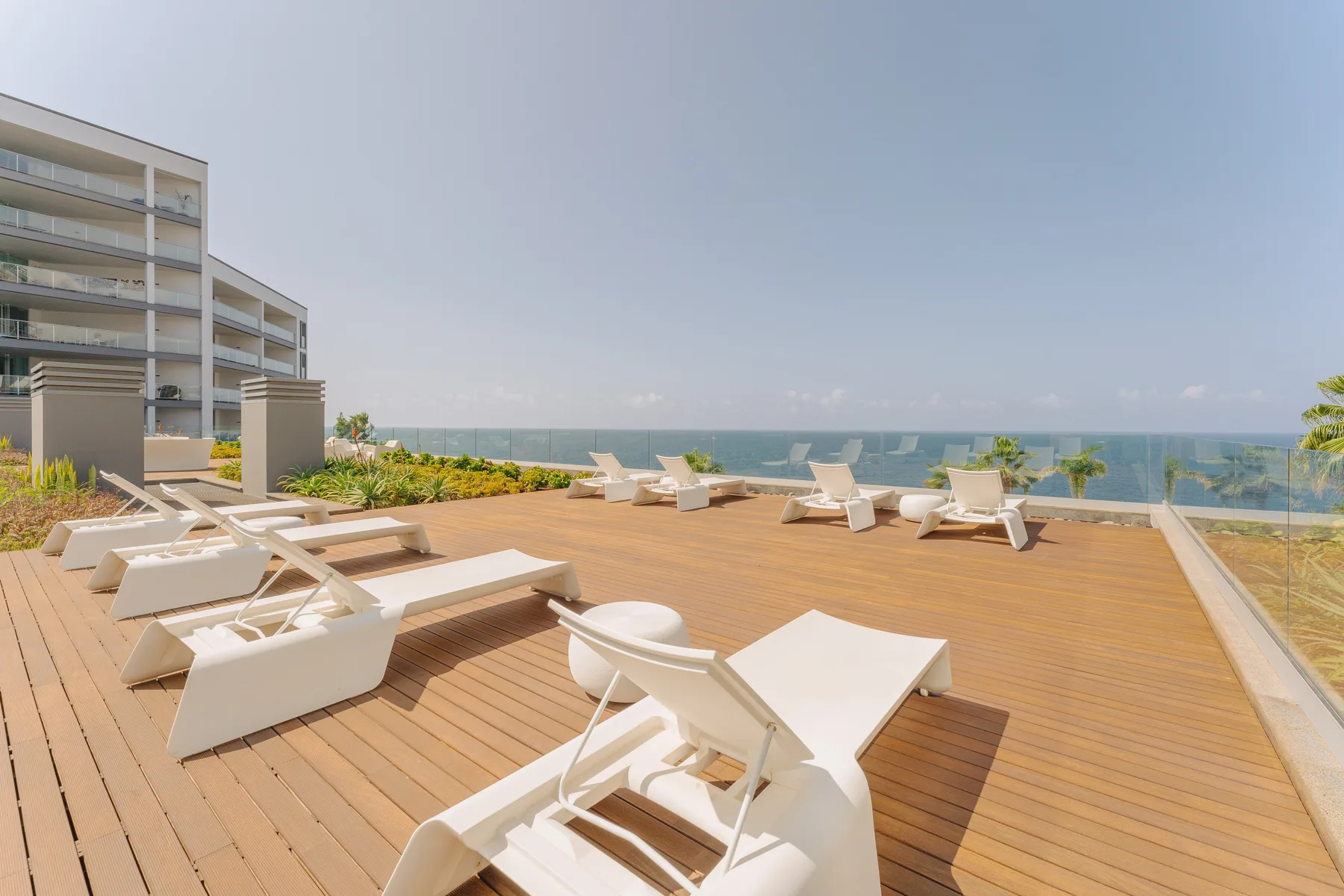 A rooftop terrace with lounge seating overlooks the ocean.