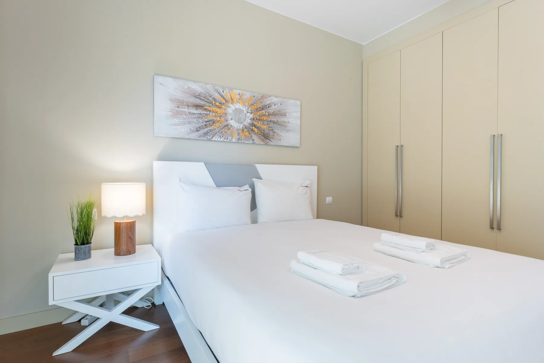 A bedroom with a neatly made bed and a wardrobe.
