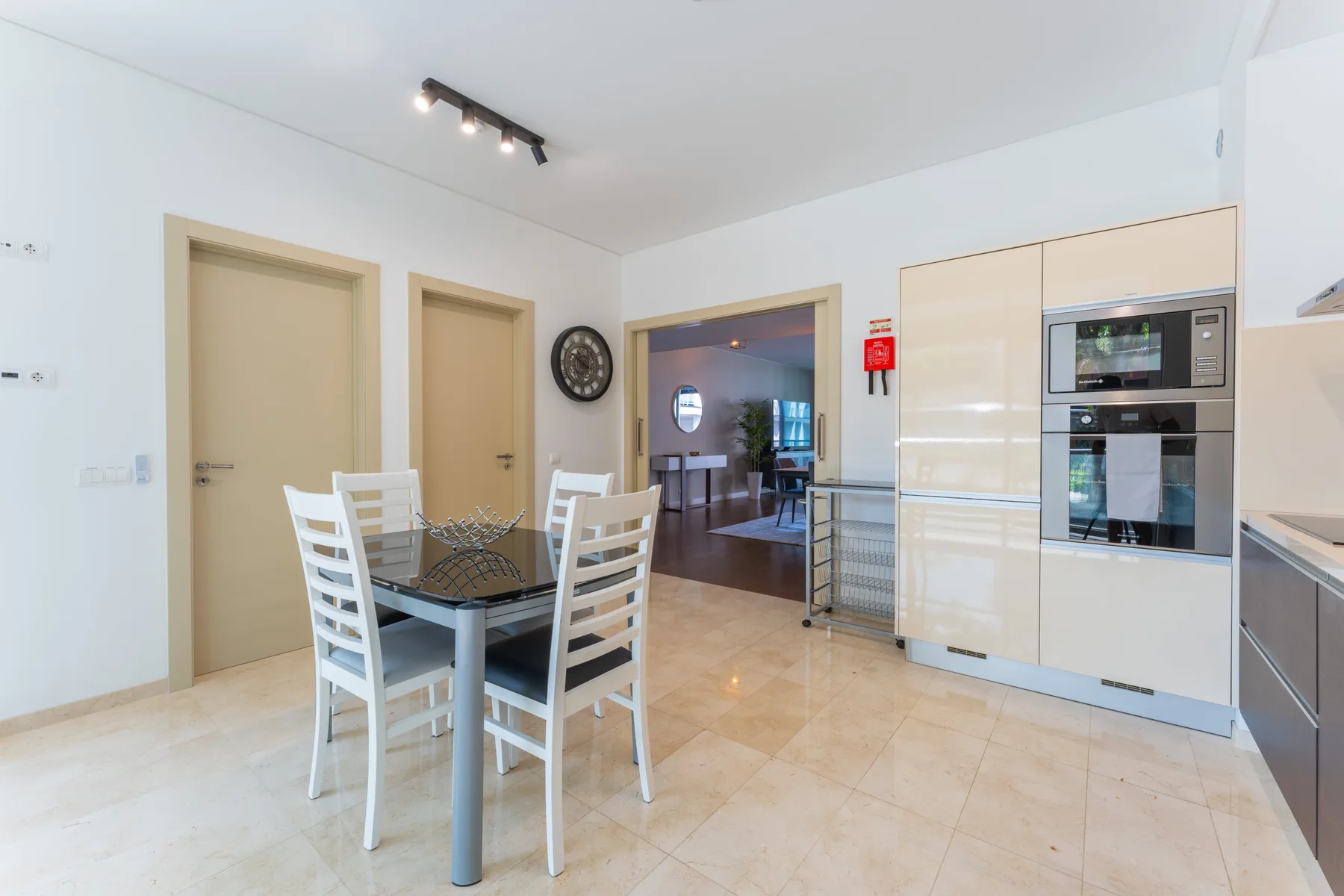 A dining area with a table and chairs beside a built-in kitchen.