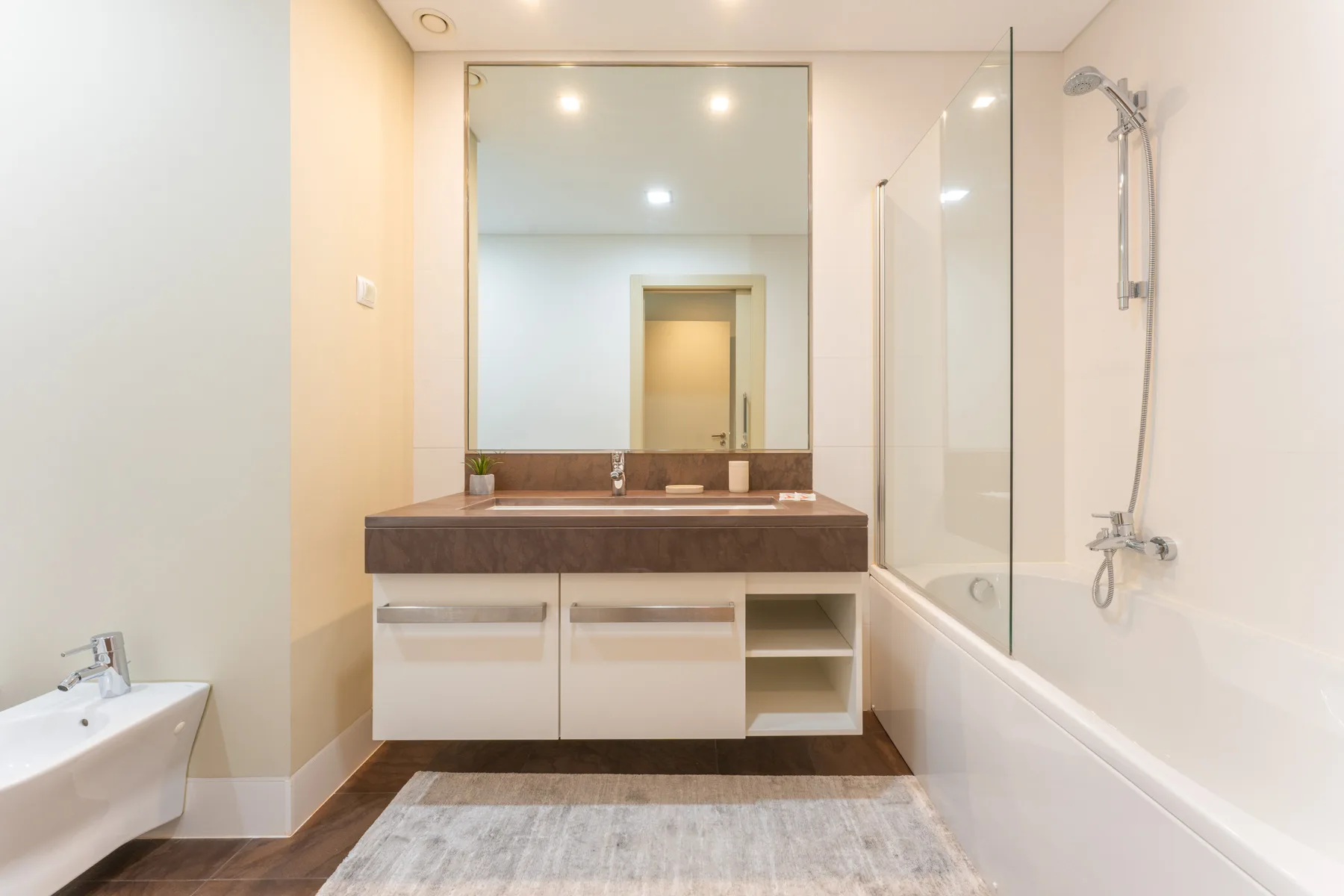 A bright bathroom with a wide sink counter and a bathtub with a shower.