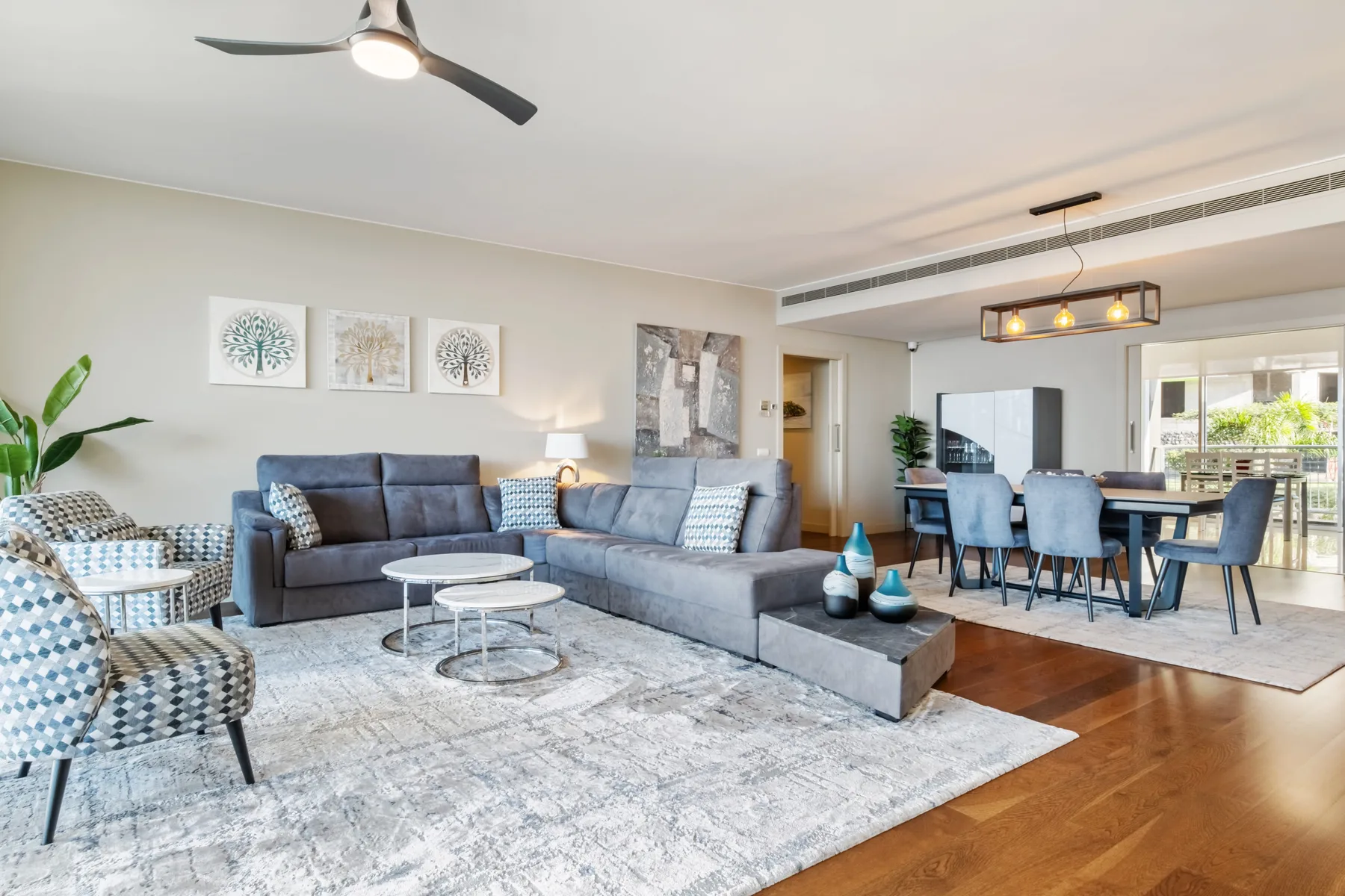 A bright living and dining area with seating, a rug, and a table.