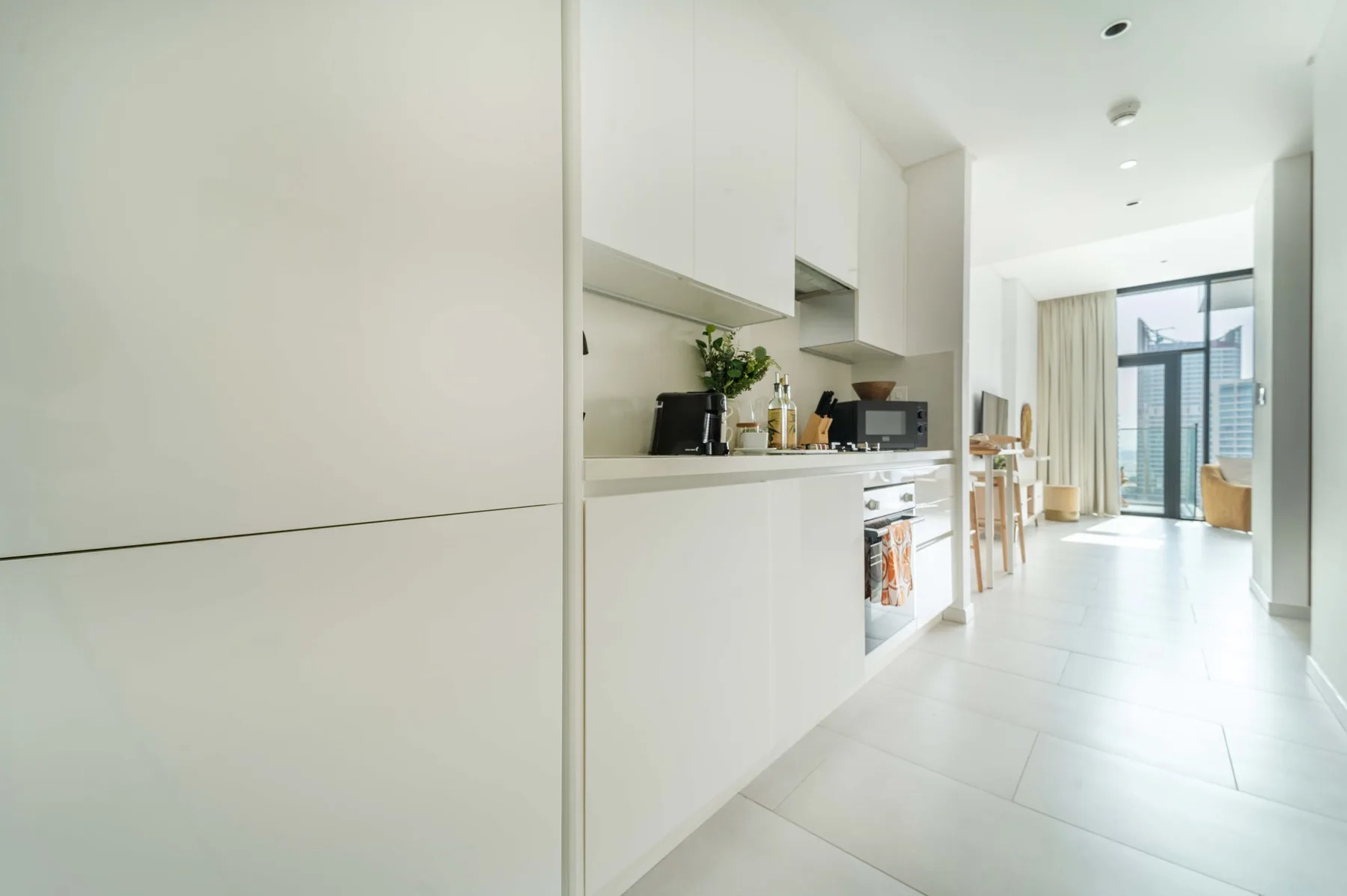 Una cocina-comedor diáfana y luminosa da a una ventana con vistas a la ciudad.