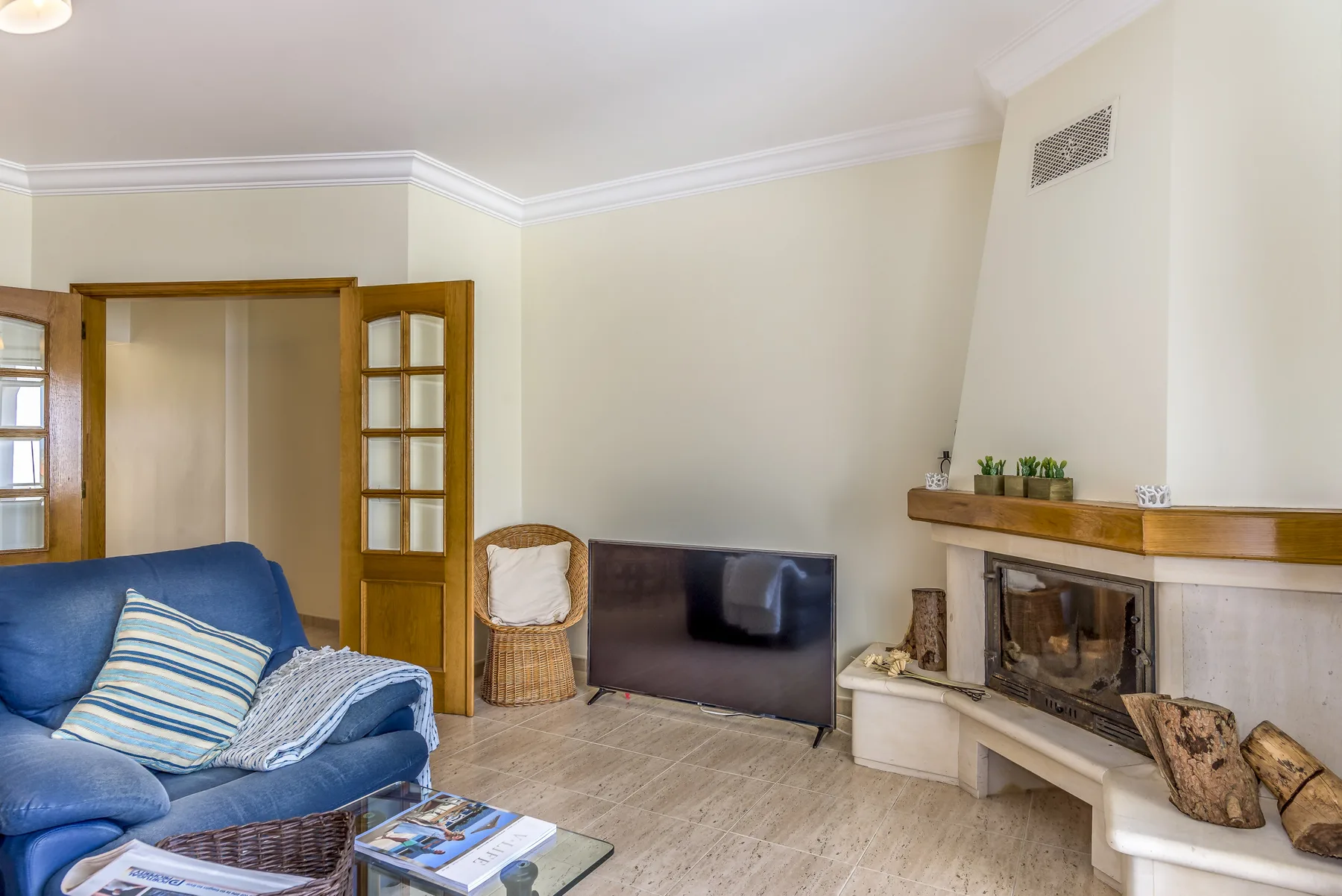 Sala de estar con asientos azules y una chimenea.