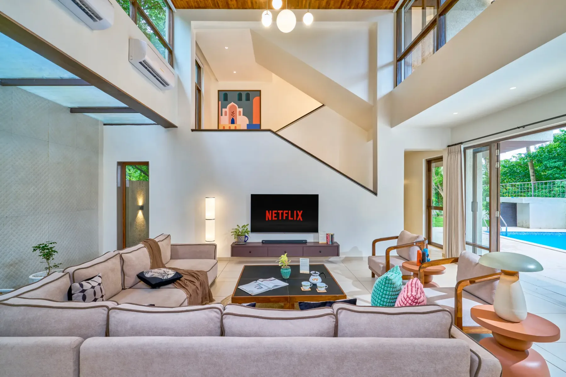 A bright living room with seating around a coffee table and television.