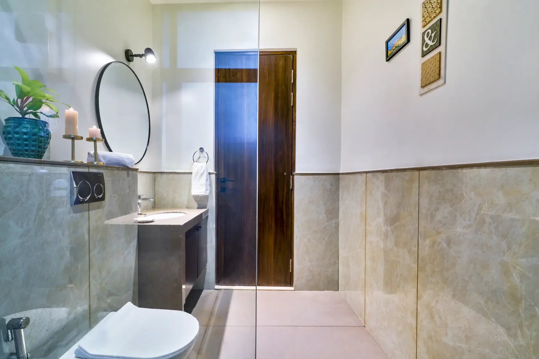 A bathroom with a vanity, mirror, and shower area.