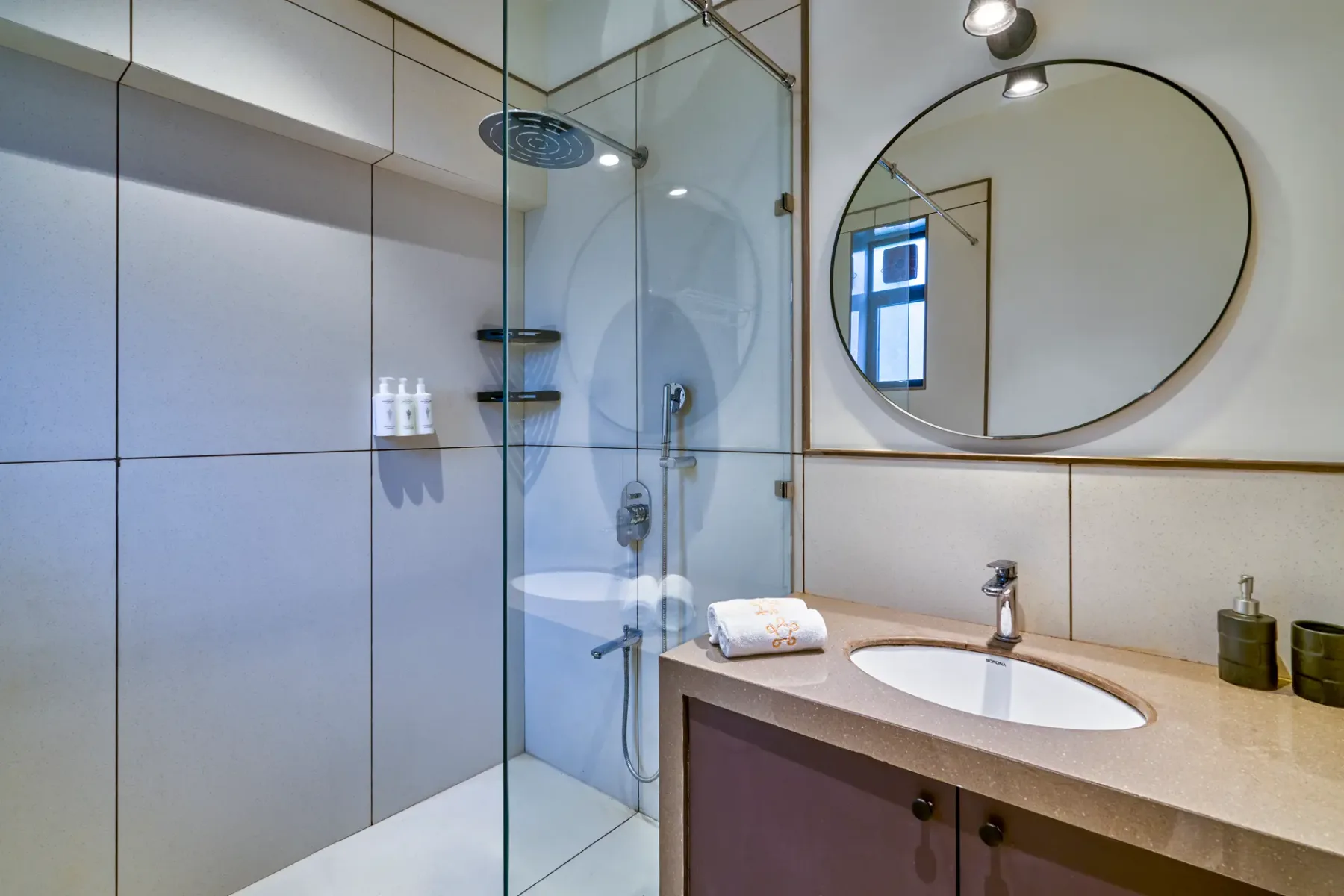 A modern bathroom with a glass shower and oval sink.