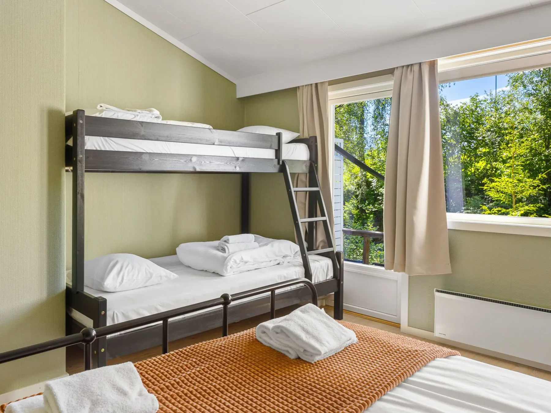 Bedroom with a dark bunk bed and a large window.