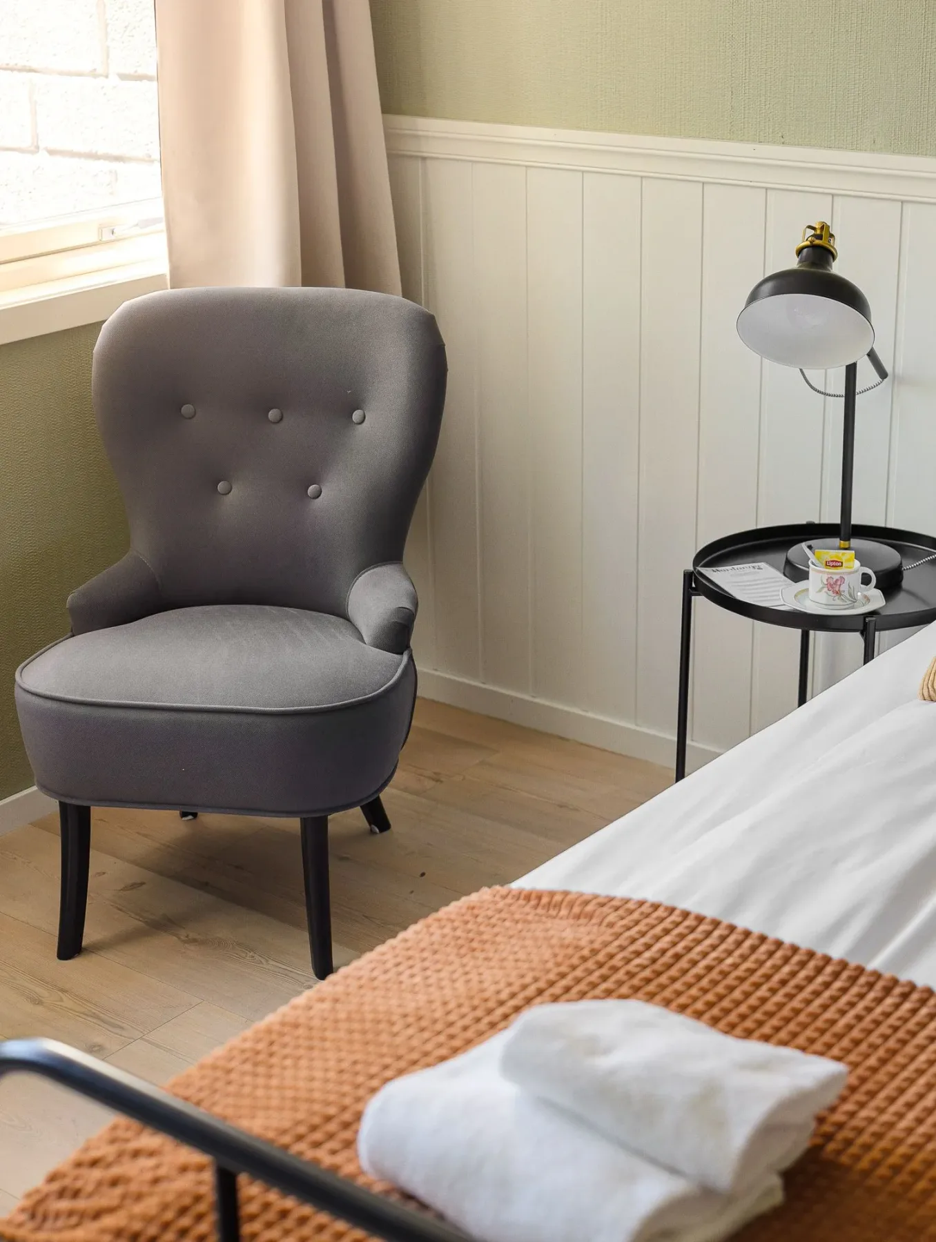 Bedroom corner with a chair and bedside lamp.