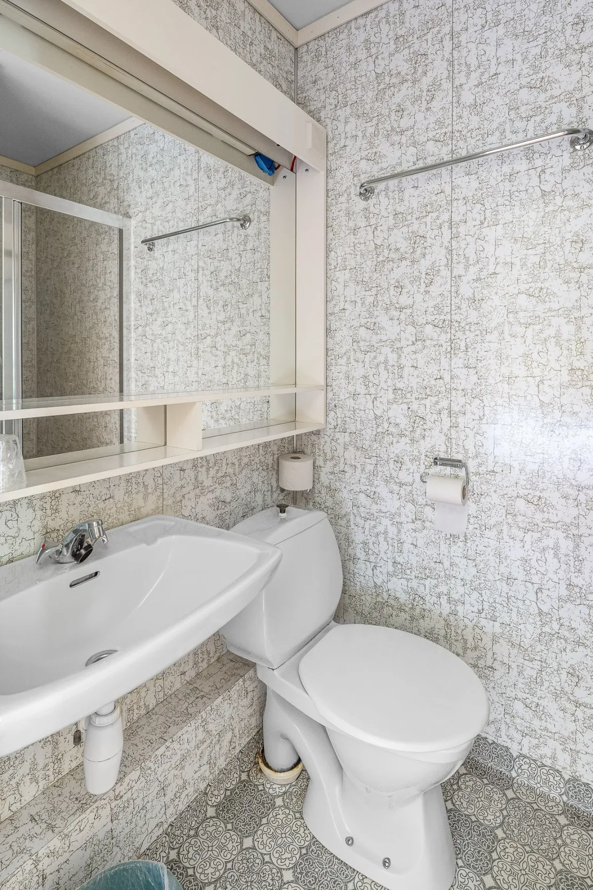 Tiled bathroom with a sink, toilet and shower.