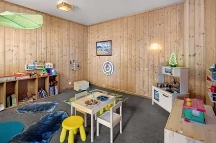 Children’s playroom with toys, a small table and stools.