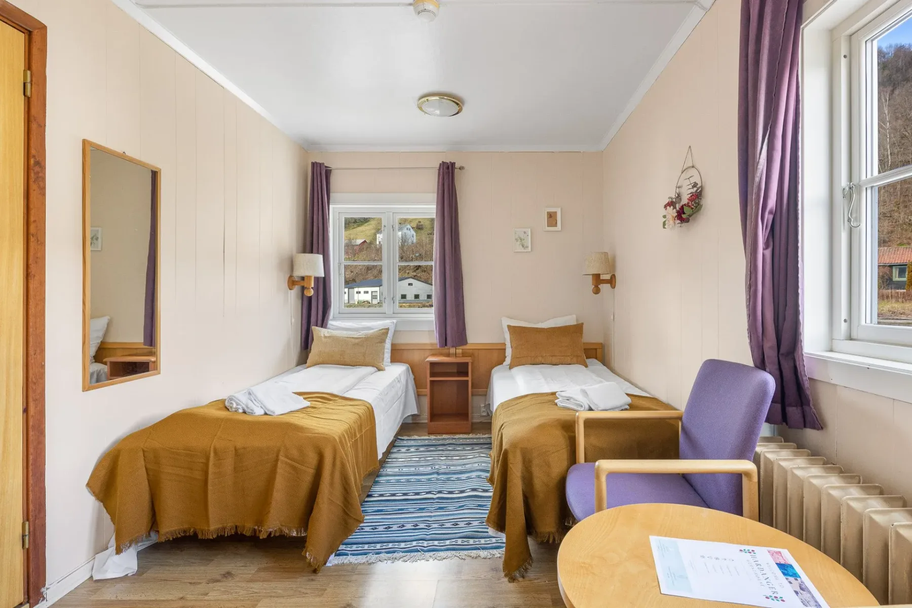 Bedroom with two twin beds and a chair by the window.