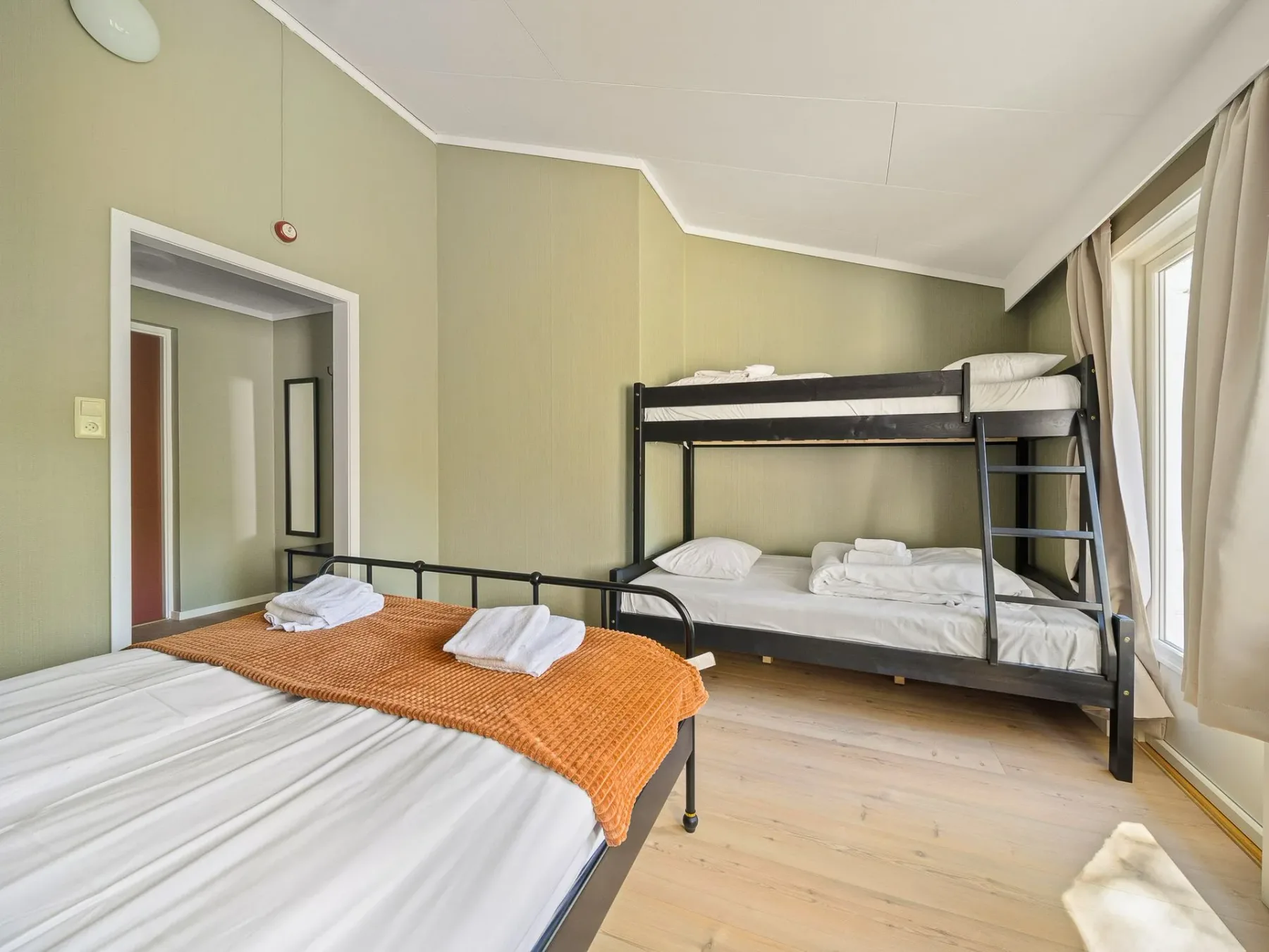 Bedroom with a twin bed, bunk bed and large windows.