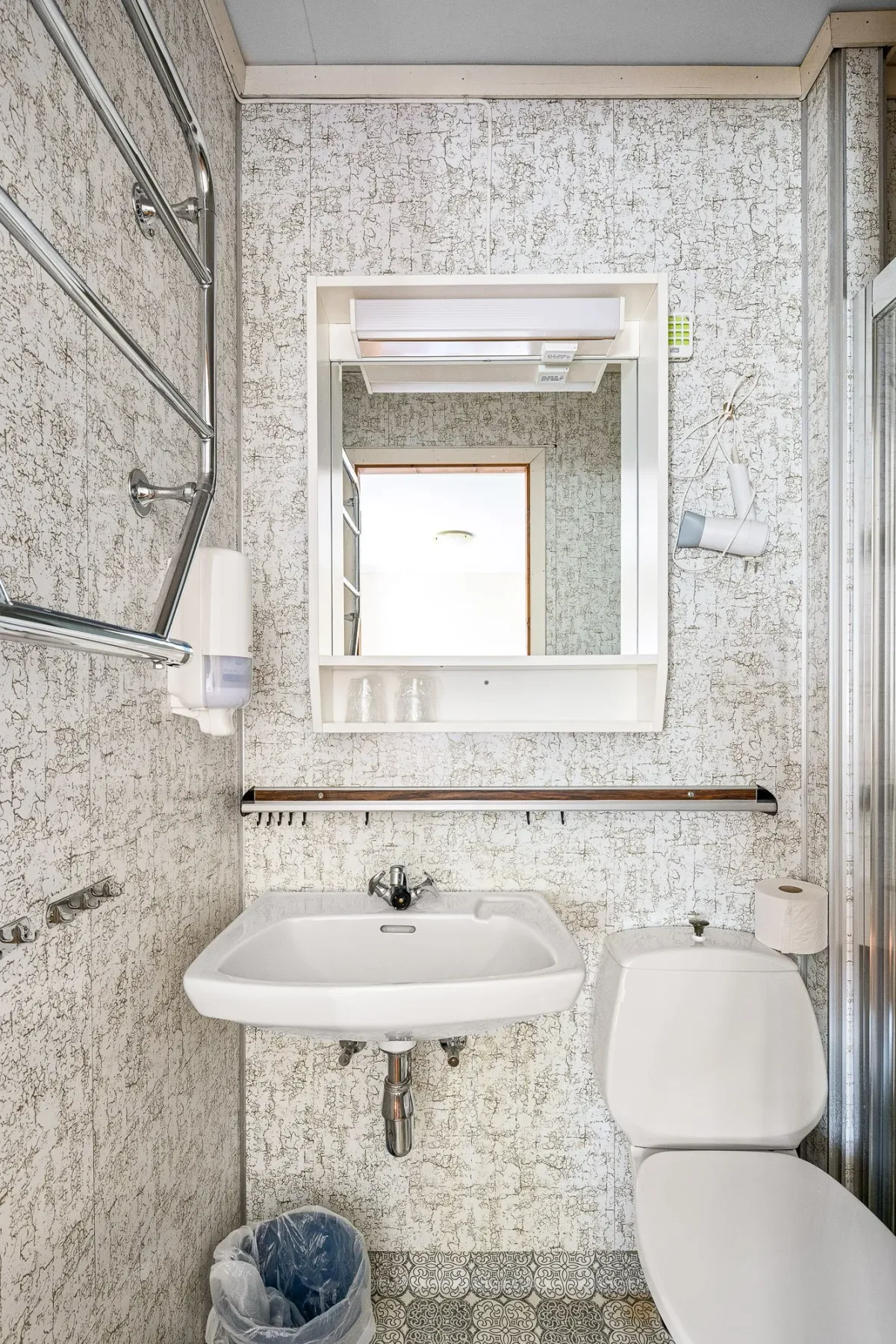 Bathroom with a sink, mirror and toilet.