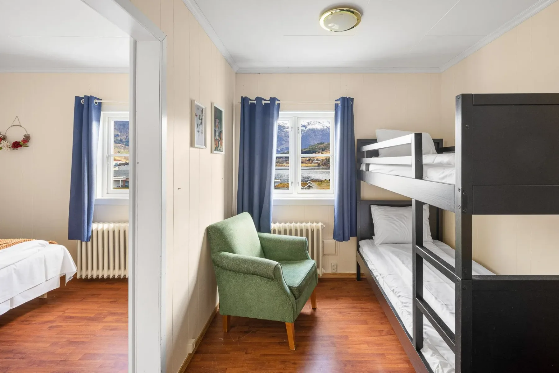 Room with bunk beds and a green armchair.