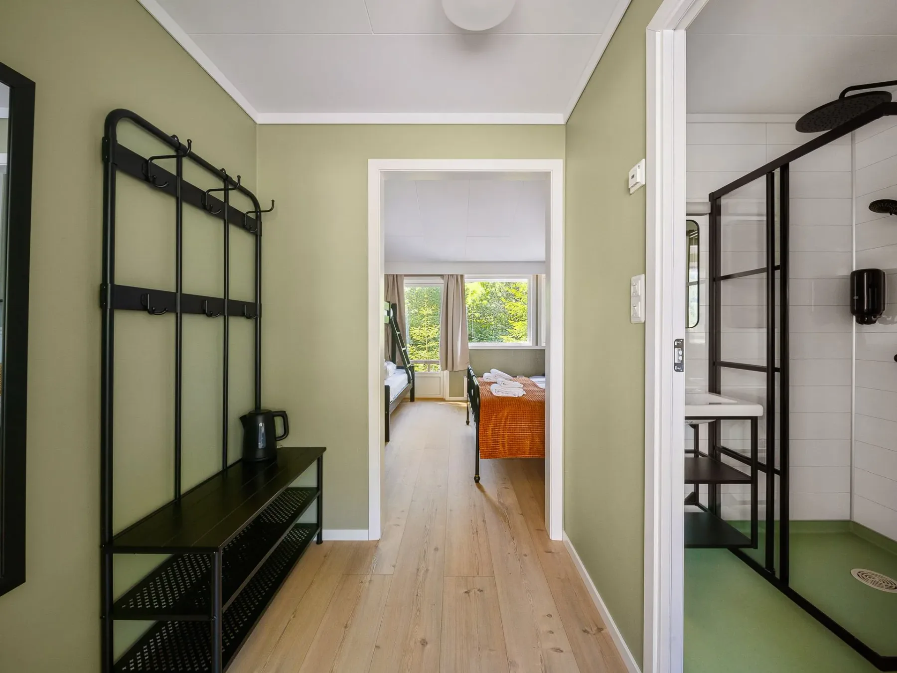 Hallway with shelving and a view into a bright room.