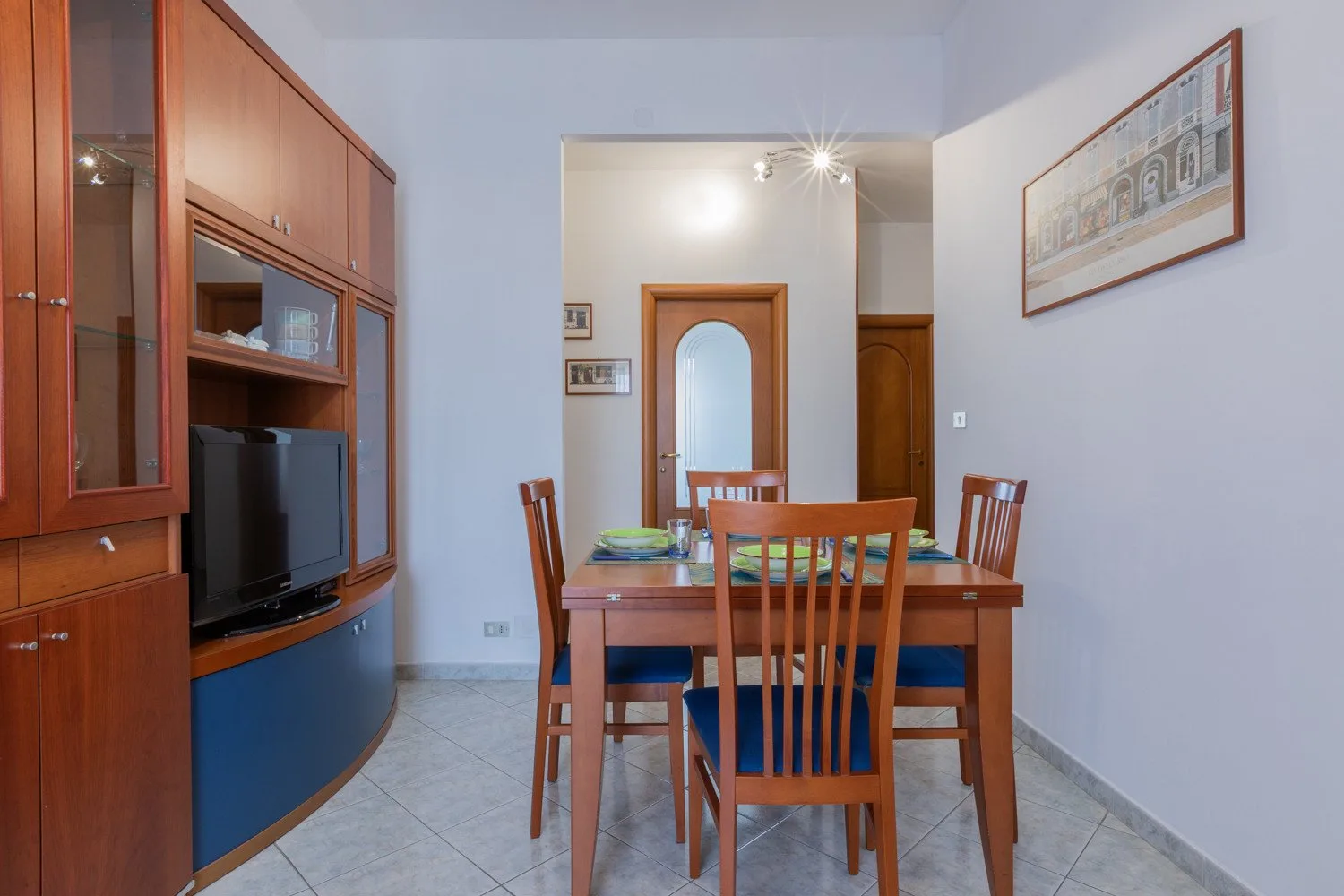 A dining area with a wooden table and chairs beside built-in cabinetry.