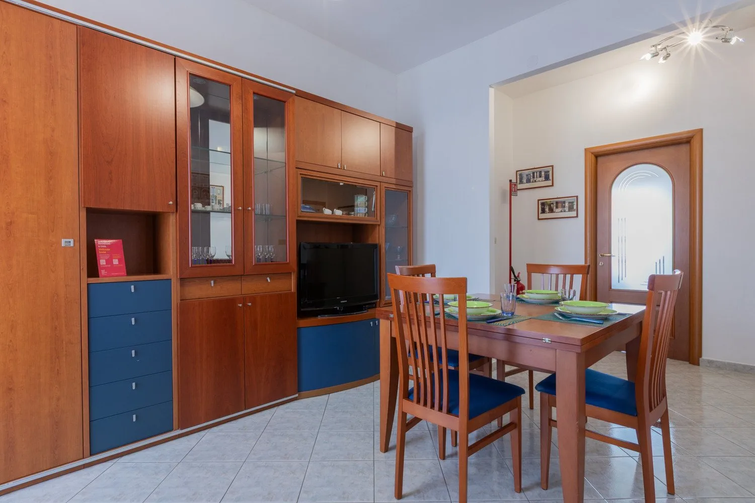 A dining area with a wooden table and built-in cabinets along the wall.