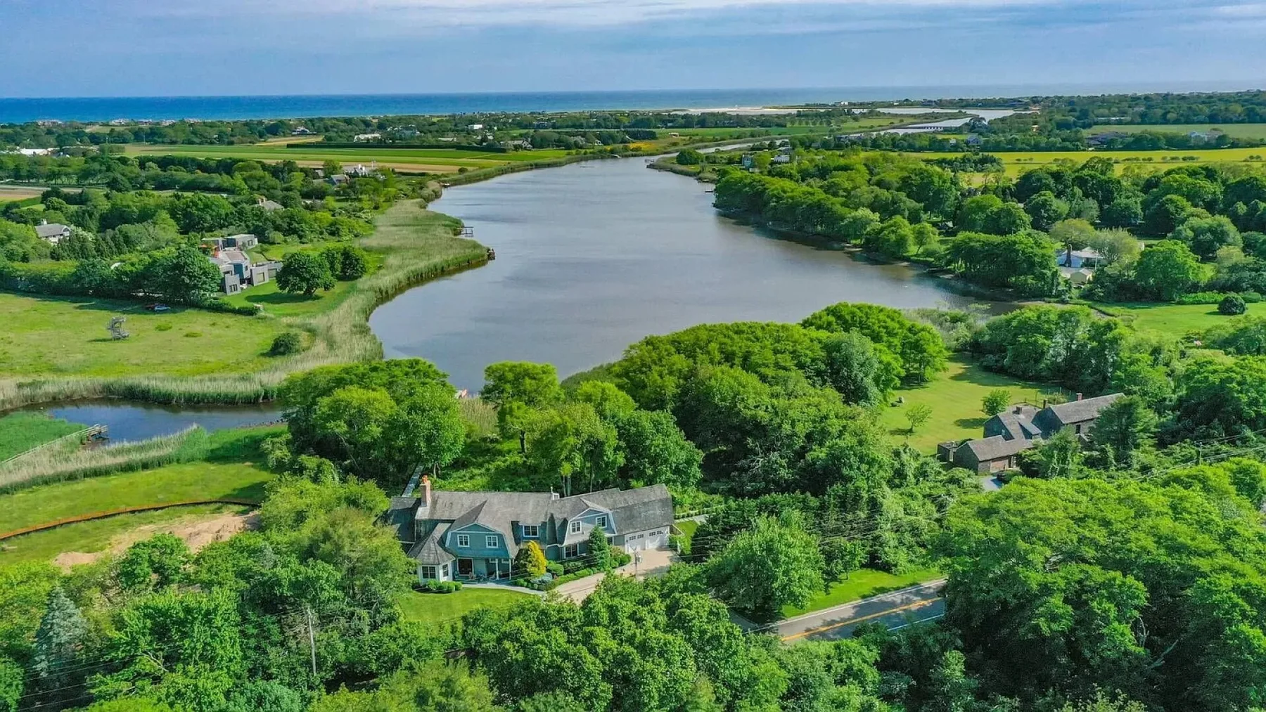 Una vista aérea muestra un río amplio que serpentea entre campos verdes y zonas arboladas.
