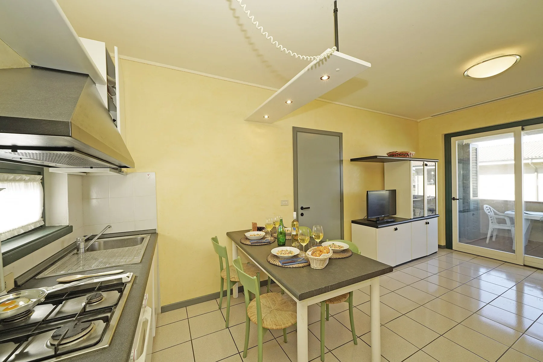 Una cocina y comedor con una mesa puesta con platos y comida.