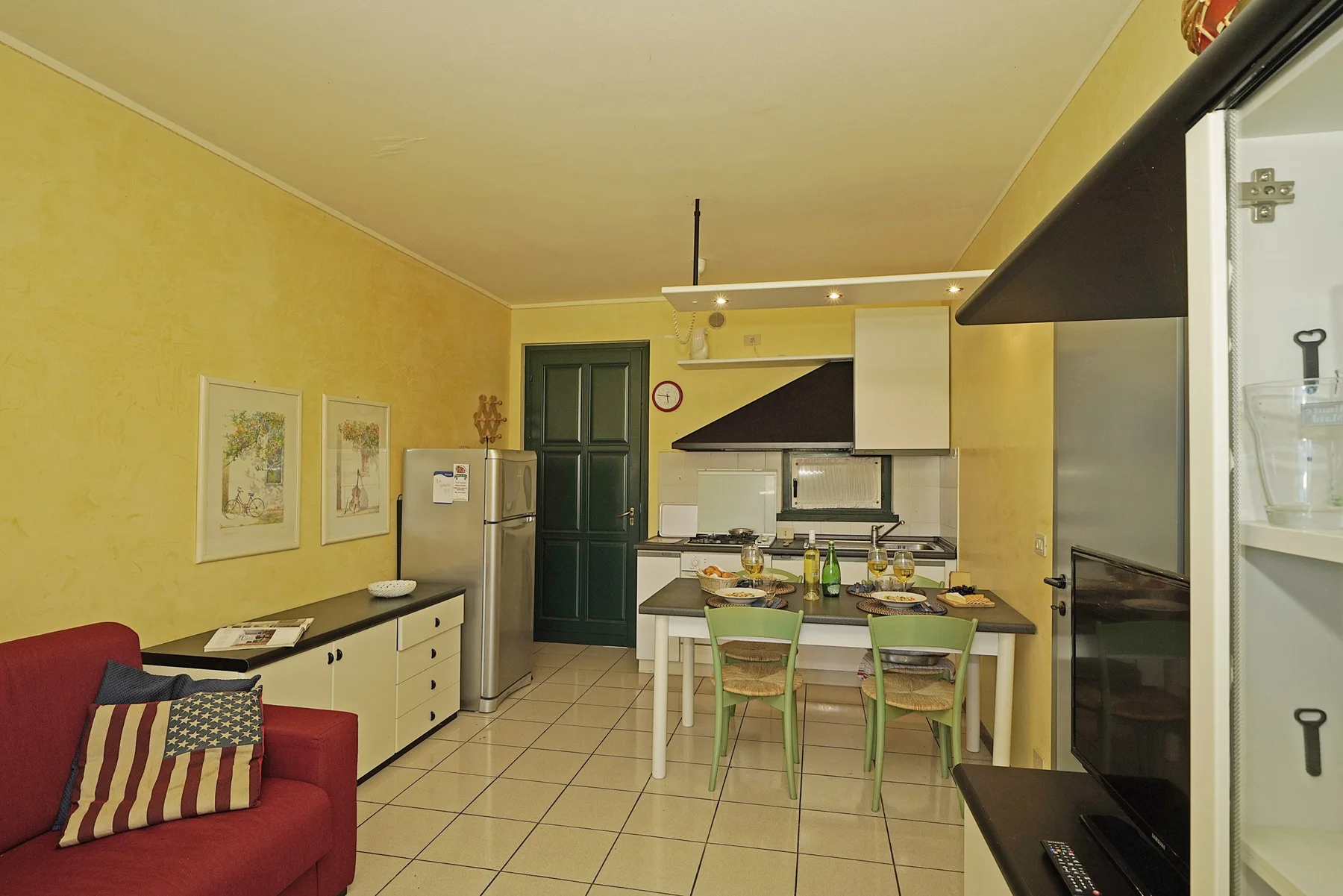 Cocina y comedor con una mesa y sillas junto a la sala de estar.