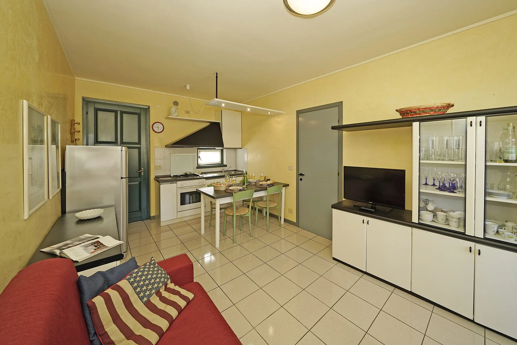 Una sala de estar y cocina combinadas tienen una mesa de comedor y un televisor.