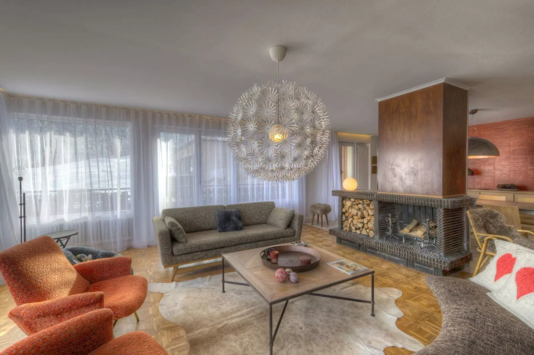 A living room with seating around a coffee table beside a fireplace.